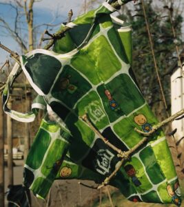 Eine grüne Plastiktüte hängt zerfleddert in einem Busch.